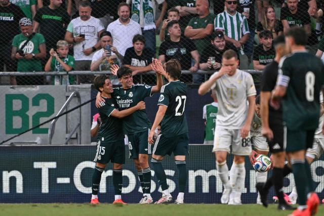 Real Madrid's Spanish defender #36 Mario Rivas (2nd L) celebrates scoring with his team-mates Real Madrid's Turkish midfielder #15 Arda Guler (L) and Real Madrid's Spanish defender #27 Joan Martinez during the pre-season football match between Ferencvaros and Real Madrid in Budapest, Hungary on August 8, 2026. Real Madrid on August 6, 2026 announced a new six-year deal for star forward Vinicius Junior and the signing of teenage sensation Yan Diomande in a major boost to their quest to end a two-year trophy drought. (Photo by Attila KISBENEDEK / AFP)