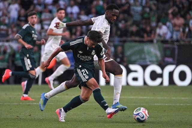 Real Madrid's Moroccan forward #21 Brahim Diaz and Ferencvaros' French defender #05 Nathan Zohore (R) vie for the ball during the pre-season football match between Ferencvaros and Real Madrid in Budapest, Hungary on August 8, 2026. Real Madrid on August 6, 2026 announced a new six-year deal for star forward Vinicius Junior and the signing of teenage sensation Yan Diomande in a major boost to their quest to end a two-year trophy drought. (Photo by Attila KISBENEDEK / AFP)