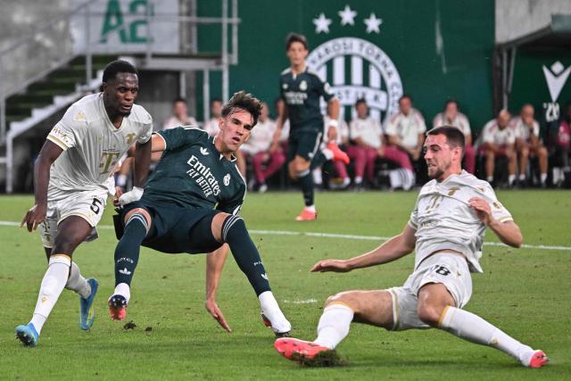 Real Madrid's Spanish forward #40 Carlos Espi (C), Ferencvaros' French defender #05 Nathan Zohore (L) and Ferencvaros' Belgian defender #28 Toon Raemaekers vie for the ball during the pre-season football match between Ferencvaros and Real Madrid in Budapest, Hungary on August 8, 2026. Real Madrid on August 6, 2026 announced a new six-year deal for star forward Vinicius Junior and the signing of teenage sensation Yan Diomande in a major boost to their quest to end a two-year trophy drought. (Photo by Attila KISBENEDEK / AFP)