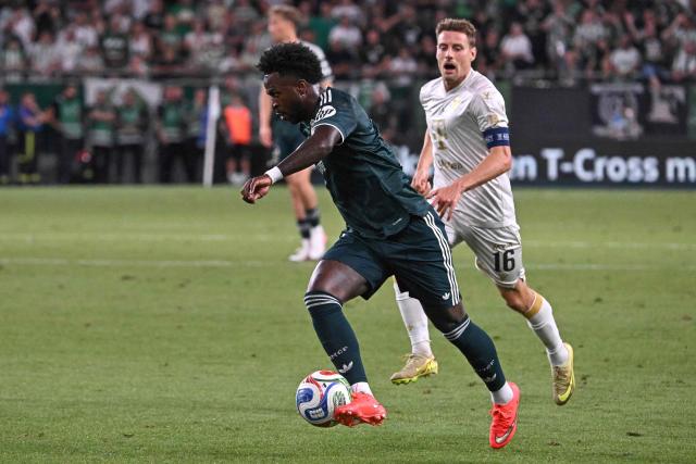 Real Madrid's Brazilian forward #07 Vinicius Junior controls the ball next to Ferencvaros' Norwegian midfielder #16 Kristoffer Zachariassen during the pre-season football match between Ferencvaros and Real Madrid in Budapest, Hungary on August 8, 2026. Real Madrid on August 6, 2026 announced a new six-year deal for star forward Vinicius Junior and the signing of teenage sensation Yan Diomande in a major boost to their quest to end a two-year trophy drought. (Photo by Attila KISBENEDEK / AFP)