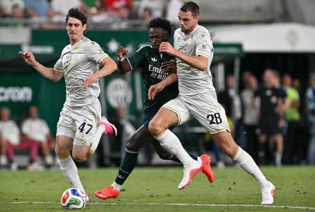 Real Madrid's Brazilian forward #07 Vinicius Junior (C) Ferencvaros' Belgian defender #28 Toon Raemaekers (R) and Ferencvaros' Irish midfielder #47 Callum O'Dowda vie for the ball during the pre-season football match between Ferencvaros and Real Madrid in Budapest, Hungary on August 8, 2026. Real Madrid on August 6, 2026 announced a new six-year deal for star forward Vinicius Junior and the signing of teenage sensation Yan Diomande in a major boost to their quest to end a two-year trophy drought. (Photo by Attila KISBENEDEK / AFP)