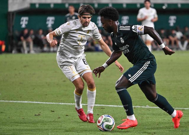 Real Madrid's Brazilian forward #07 Vinicius Junior (R) and Ferencvaros' Hungarian midfielder #06 Adam Nagy vie for the ball during the pre-season football match between Ferencvaros and Real Madrid in Budapest, Hungary on August 8, 2026. Real Madrid on August 6, 2026 announced a new six-year deal for star forward Vinicius Junior and the signing of teenage sensation Yan Diomande in a major boost to their quest to end a two-year trophy drought. (Photo by Attila KISBENEDEK / AFP)