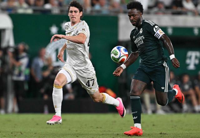 Real Madrid's Brazilian forward #07 Vinicius Junior (R) and Ferencvaros' Irish midfielder #47 Callum O'Dowda vie for the ball during the pre-season football match between Ferencvaros and Real Madrid in Budapest, Hungary on August 8, 2026. Real Madrid on August 6, 2026 announced a new six-year deal for star forward Vinicius Junior and the signing of teenage sensation Yan Diomande in a major boost to their quest to end a two-year trophy drought. (Photo by Attila KISBENEDEK / AFP)