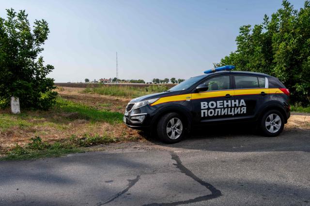 A Bulgarian military police car is parked at anaccess to a farmland area where a drone that entered Bulgaria exploded, near the Kardam border-crossing between Bulgaria and Romania, on August 8, 2026. Ukraine on August 8 denied targeting Bulgaria after a drone exploded close to the strategic Trans-Balkan gas pipeline linking Turkey to Ukraine near the Romanian border. (Photo by Mihail IVANOV / AFP)