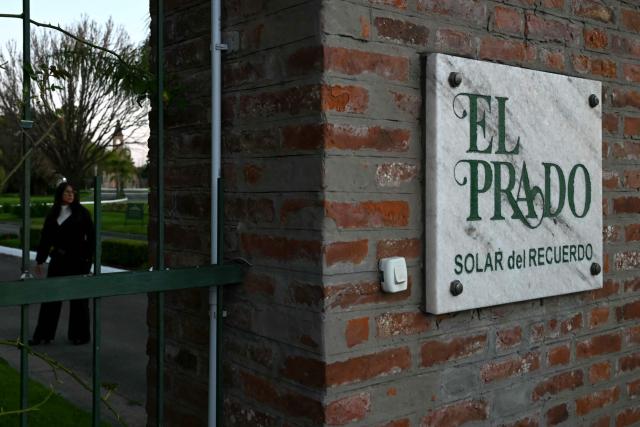 A woman stands at the entrance to El Prado cemetery on the outskirts of Rosario, Santa Fe province, Argentina, on August 8, 2026. Jorge Messi, the father and agent of Lionel Messi, has died aged 68, the eight-time Ballon d'Or winner's childhood club Newell's Old Boys announced on August 8, 2026. (Photo by Luis ROBAYO / AFP)