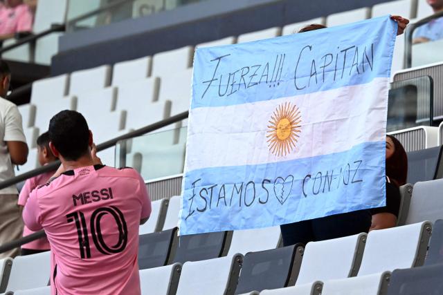 Inter Miami fans hold an Argentine flag with a message to football star Lionel Messi ahead of the Leagues Cup 2026 group-stage football match between Inter Miami CF and Monterrey at Nu Stadium in Miami, Florida, on August 8, 2026. Jorge Messi, the father and agent of Lionel Messi, has died aged 68 in Rosario, Argentina, the eight-time Ballon d'Or winner's childhood club Newell's Old Boys announced on August 8. (Photo by CHANDAN KHANNA / AFP)