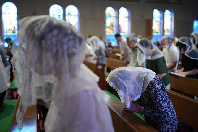 People pray at a mass held at Urakami Cathedral on August 9, 2026 in Nagasaki, marking the 81st anniversary of the atomic bombing. (Photo by JIJI Press / AFP) / Japan OUT