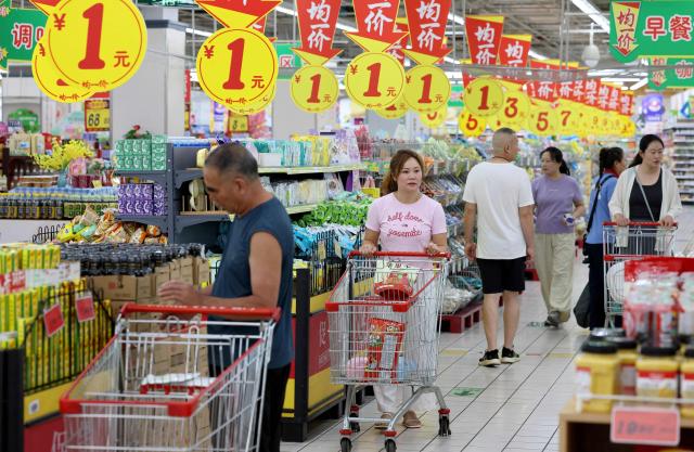 Consumers select products at a supermarket in Zaozhuang, in eastern China's Shandong province, on August 9, 2026. (Photo by CN-STR / AFP) / China OUT