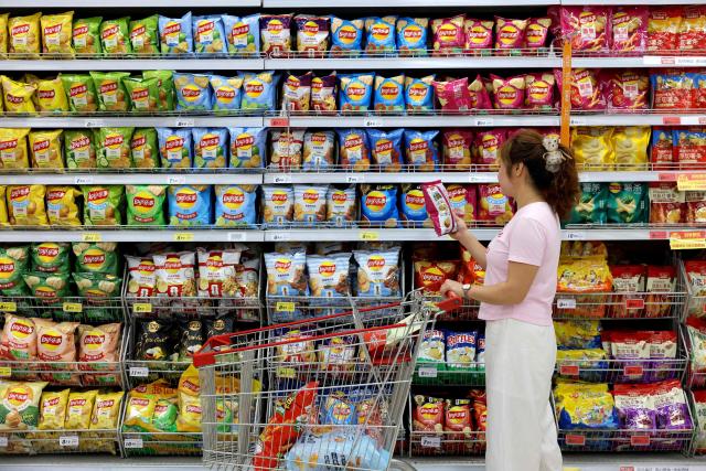 A consumer selects a product at a supermarket in Zaozhuang, in eastern China's Shandong province, on August 9, 2026. (Photo by CN-STR / AFP) / China OUT