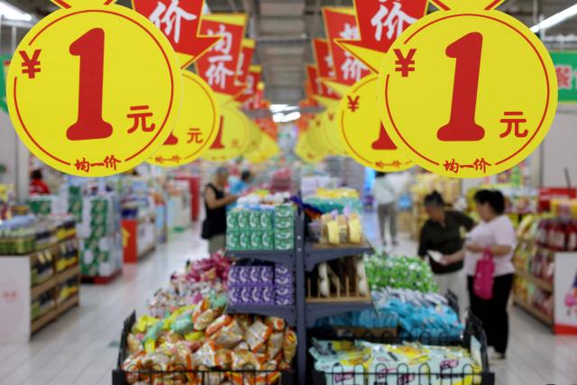 Consumers select products at a supermarket in Zaozhuang, in eastern China's Shandong province, on August 9, 2026. (Photo by CN-STR / AFP) / China OUT