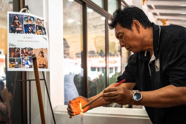 A mourner prays for 12-year-old school shooting victim Naphat Chaima during her funeral at the Wat Lat Pla Duk Buddhist temple in Nonthaburi province, north of Thailand's capital Bangkok, on August 9, 2026. A teenage assailant shot his grandparents, using his grandfather's handgun, at their home north of Bangkok on August 7 before going on a killing spree at his secondary school and ultimately turning the gun on himself, according to authorities. (Photo by Chanakarn LAOSARAKHAM / AFP)