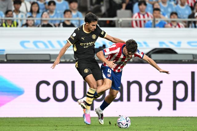 Manchester City’s Vitor Reis (L) competes for the ball with Atletico Madrid’s Rodrigo Mendoza during their pre-season exhibition friendly football match at Seoul World Cup Stadium in Seoul on August 9, 2026. (Photo by GREG BAKER / AFP)
