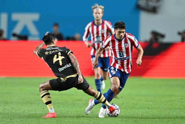 Manchester City’s Tijjani Reijnders (L) competes for the ball with Atletico Madrid’s Rayan Ait Nouri (R) during their pre-season exhibition friendly football match at Seoul World Cup Stadium in Seoul on August 9, 2026. (Photo by GREG BAKER / AFP)