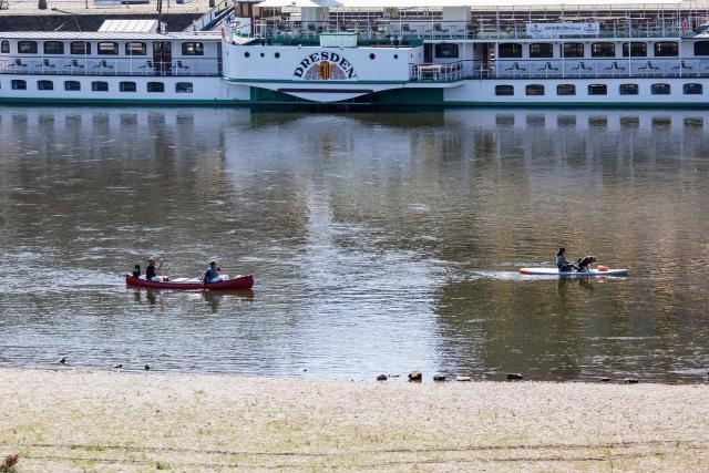 Paddlers paddle on the river Elbe as a long riverbed is seen in Dresden, eastern Germany, on August 9, 2026, with hot and dry weather conditions keeping very low the water level of the river. (Photo by Jens SCHLÜTER / AFP)