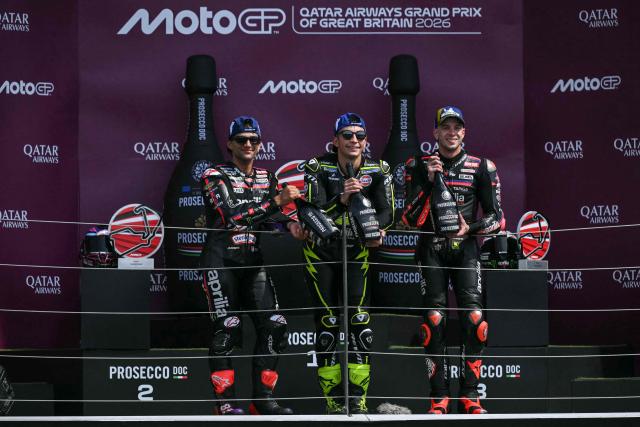Winner Trackhouse MotoGP's Spanish rider Raul Fernandez (C) celebrates his victory on the podium with second-placed Aprilia Racing's Spanish rider Jorge Martin (L) and third-placed Aprilia Racing's Italian rider Marco Bezzecchi (R) at the end of the MotoGP British Grand Prix at Silverstone circuit, central England on August 9, 2026. (Photo by Glyn KIRK / AFP)