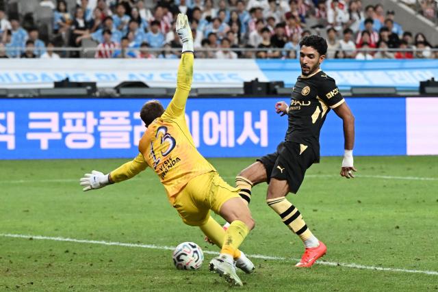 Manchester City’s Omar Marmoush (R) scores his second goal past Atletico Madrid’s keeper Jan Oblak during their pre-season exhibition friendly football match at Seoul World Cup Stadium in Seoul on August 9, 2026. (Photo by GREG BAKER / AFP)