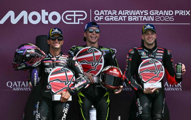 Winner Trackhouse MotoGP's Spanish rider Raul Fernandez (C) celebrates his victory on the podium with second-placed Aprilia Racing's Spanish rider Jorge Martin (L) and third-placed Aprilia Racing's Italian rider Marco Bezzecchi (R) at the end of the MotoGP British Grand Prix at Silverstone circuit, central England on August 9, 2026. (Photo by Glyn KIRK / AFP)