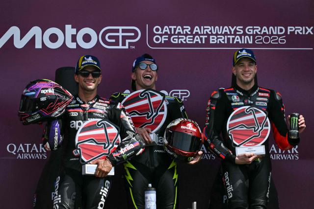 Winner Trackhouse MotoGP's Spanish rider Raul Fernandez (C) celebrates his victory on the podium with second-placed Aprilia Racing's Spanish rider Jorge Martin (L) and third-placed Aprilia Racing's Italian rider Marco Bezzecchi (R) at the end of the MotoGP British Grand Prix at Silverstone circuit, central England on August 9, 2026. (Photo by Glyn KIRK / AFP)