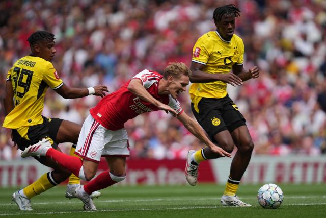 Dortmund's Italian defender #39 Filippo Mane (L) fouls Arsenal's Norwegian midfielder #08 Martin Odegaard (C) during the English Premier League football match between Arsenal and Borussia Dortmund at the Emirates Stadium in London on August 9, 2026. (Photo by CARLOS JASSO / AFP)