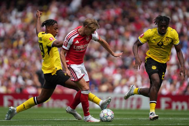 Dortmund's Italian defender #39 Filippo Mane (L) fouls Arsenal's Norwegian midfielder #08 Martin Odegaard (C) during the English Premier League football match between Arsenal and Borussia Dortmund at the Emirates Stadium in London on August 9, 2026. (Photo by CARLOS JASSO / AFP)