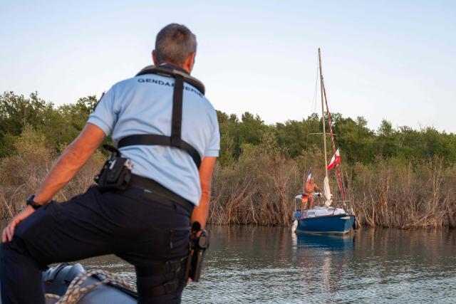 French gendarmes patrol on a boat to monitor for illegal wild camping and forest fire risks around Lake Sainte-Croix, southeastern France on August 8, 2026. At nightfall, two gendarmes scan the shores of Lake Sainte-Croix—located at the gateway to the Verdon Gorge—with binoculars, looking for potential campers. Their mission: to prevent any illegal camping that could spark a fire in the surrounding woodlands. (Photo by Miguel MEDINA / AFP)