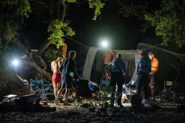 French gendarmes check on tourists to prevent wild camping and forest fire risks around Lake Sainte-Croix, southeastern France on August 8, 2026. At nightfall, two gendarmes scan the shores of Lake Sainte-Croix—located at the gateway to the Verdon Gorge—with binoculars, looking for potential campers. Their mission: to prevent any illegal camping that could spark a fire in the surrounding woodlands. (Photo by Miguel MEDINA / AFP)