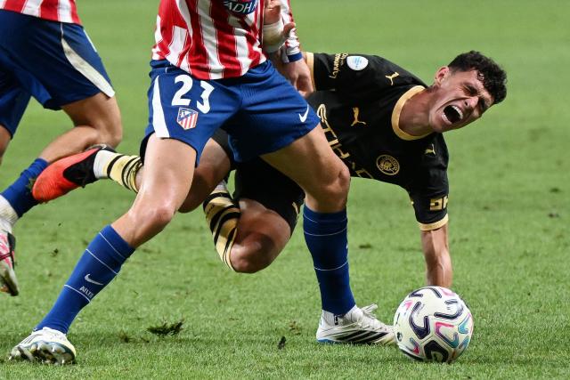 Manchester City's Phil Foden falls in a collision with Atletico Madrid's Morten Hjulmand during their exhibition football match at Seoul World Cup Stadium in Seoul on August 9, 2026. (Photo by GREG BAKER / AFP)