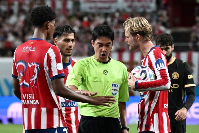 Atletico Madrid’s Morten Hjulmand (R) argues with the referee after being penalised for fouling Manchester City’s Phil Foden (not seen), as teammate Jorge Dominguez (L) looks on during their exhibition football match at Seoul World Cup Stadium in Seoul on August 9, 2026. (Photo by GREG BAKER / AFP)