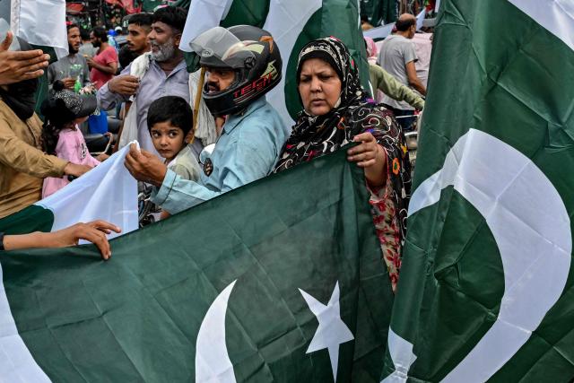 People buy national flags at a marketplace ahead of the country's Independence Day celebration in Lahore on August 9, 2026. (Photo by Arif ALI / AFP)