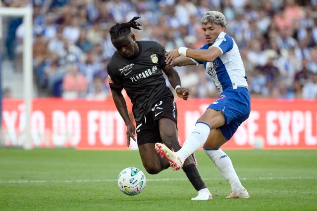 FC Alverca's Nigerian defender #12 Isaac James (L) and FC Porto's Brazilian forward #07 William Gomes fight for the ball during the Portuguese League football match between FC Porto and FC Alverca at Dragao stadium in Porto on August 8, 2026. (Photo by Miguel RIOPA / AFP)