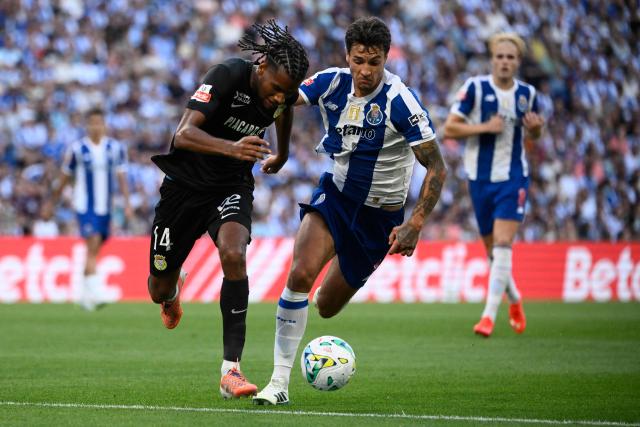 FC Alverca's French defender #14 Steven Baseya and FC Porto's Polish defender #04 Jakub Piotr Kiwior fight for the ball during the Portuguese League football match between FC Porto and FC Alverca at Dragao stadium in Porto on August 8, 2026. (Photo by Miguel RIOPA / AFP)