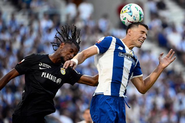 FC Alverca's French defender #14 Steven Baseya (L) and FC Porto's Polish defender #05 Jan Bednarek fight for a header during the Portuguese League football match between FC Porto and FC Alverca at Dragao stadium in Porto on August 8, 2026. (Photo by Miguel RIOPA / AFP)