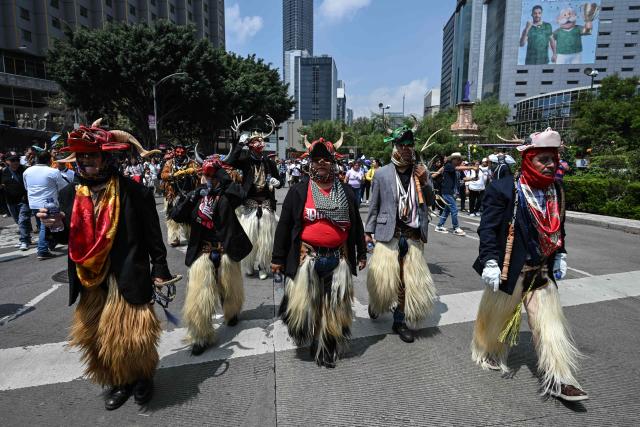 Members of an indigenous community wear traditional costumes while participating in the "Mega Calenda" parade, which commemorates the International Day of the World's Indigenous Peoples, in Mexico City on August 9, 2026. (Photo by Yuri CORTEZ / AFP)