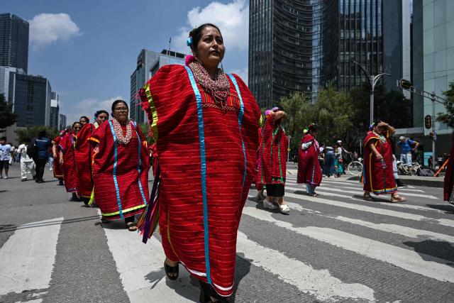 Members of an indigenous community wear traditional costumes while participating in the "Mega Calenda" parade, which commemorates the International Day of the World's Indigenous Peoples, in Mexico City on August 9, 2026. (Photo by Yuri CORTEZ / AFP)