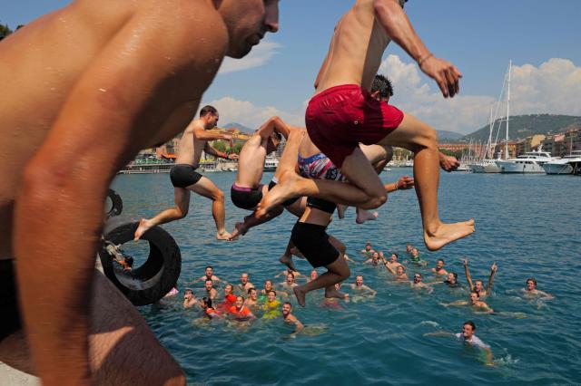 Members of the 'Caravane du Tour' jump in the port prior to the 9th and final stage of the fifth edition of the Women's Tour de France cycling race, 99.2 km from Nice to Nice, southeastern France on August 9, 2026. (Photo by Valery HACHE / AFP)