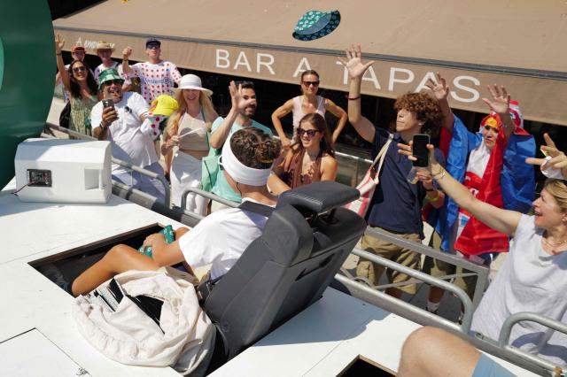 Spectators try to catch goodies of the 'Caravane du Tour' prior to the 9th and final stage of the fifth edition of the Women's Tour de France cycling race, 99.2 km from Nice to Nice, southeastern France on August 9, 2026. (Photo by Valery HACHE / AFP)