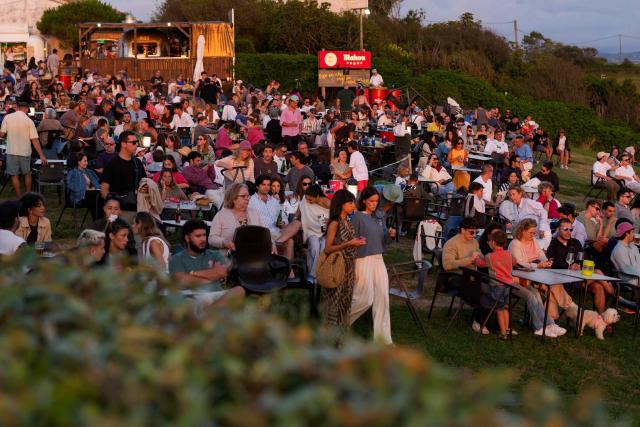 People gather to watch the sunset at "El Rayo Verde" viewpoint, in San Vicente de la Barquera in the province of Cantabria, northern Spain, on August 9, 2026. Spain, one of the few places in the world where the solar eclipse of August 12 will be seen in totality, is beginning preparations for a phenomenon expected to shift traditional summer tourism from beaches to the countryside. (Photo by CESAR MANSO / AFP)