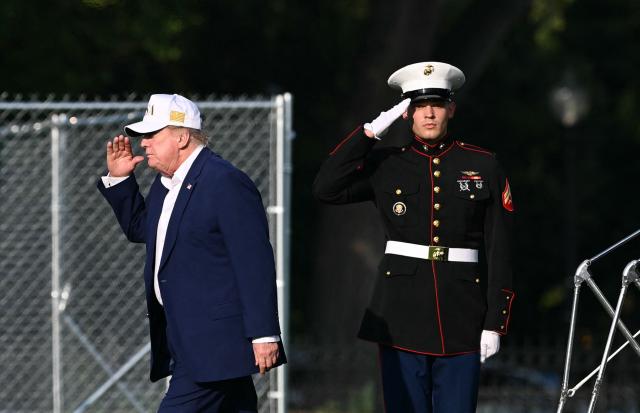 A US Marine salutes US President Donald Trump as he steps off Marine One after landing on the Ellipse near the White House in Washington, DC, on August 9, 2026. President Trump is returning to the White House after spending the weekend at his National Golf Club in Bedminster, New Jersey. (Photo by Brendan SMIALOWSKI / AFP)