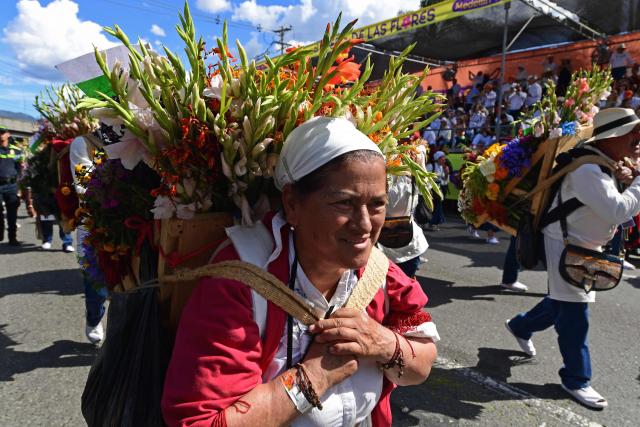 Farmers carry flower arrangements known as "silletas" during the traditional Silleteros parade held as part of the Flower Festival in Medellin, Antioquia department, Colombia on August 9, 2026. (Photo by Jaime SALDARRIAGA / AFP)