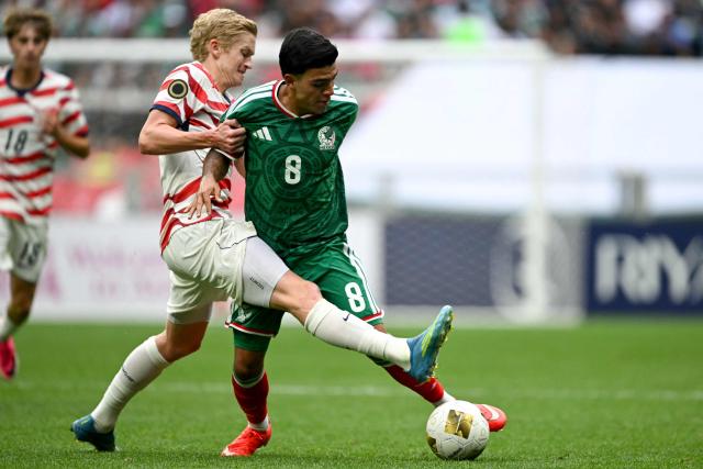 Mexico's midfielder #08 Juan Sigala (R) and US midfielder #06 Colin Guske fight for the ball during the Concacaf U-20 Championship final football match between United States and Mexico at the Banorte Stadium in Mexico City on August 9, 2026. (Photo by Yuri CORTEZ / AFP)