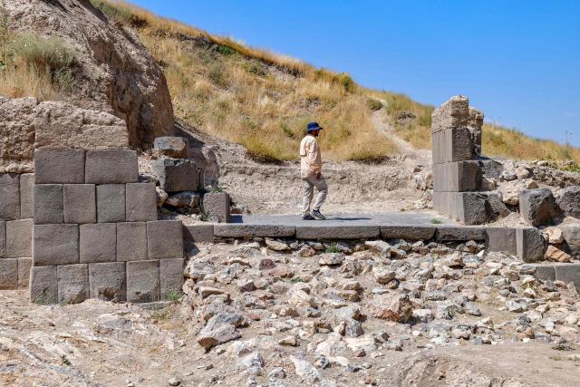 EDITORS NOTE: Graphic content / An archaeologist walk walks through the ruins of the fortress of Ayanis near Van, in eastern Turkey, on August 4, 2026. Although it emerged later than the great Mesopotamian kingdoms of Assyria, Sumer, and Babylon, Urartu succeeded in uniting the tribal communities of the Autoru Mountains into a centralized state, building fortresses, provincial capitals, irrigation networks, and vast storage facilities to support an agricultural economy. (Photo by Ali IHSAN OZTURK / AFP)