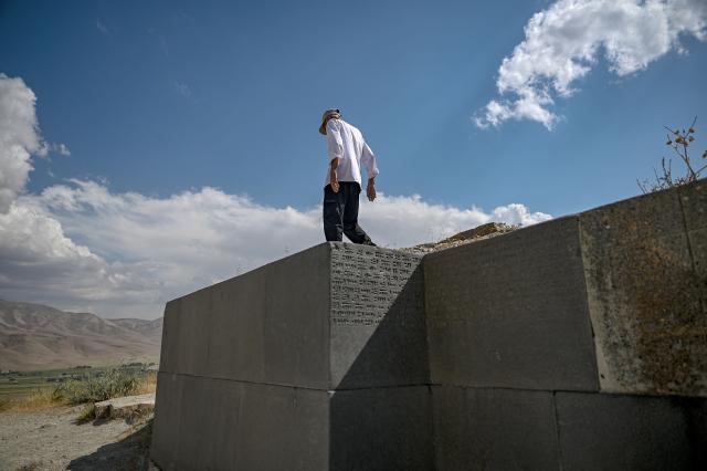 Mehmet Kusman, aged 86, who speaks Urartian language, walks at the site of the fortress of Cavustepe near Van, in eastern Turkey, on July 22, 2026. Mehmet Kusman, 86, has dedicated his life to the Cavustepe Fortress in eastern Turkey and to studying the Urartian language, which borrows its cuneiform alphabet from Assyrian to honor the gods and rulers of the lost kingdom. (Photo by Ozan KOSE / AFP)
