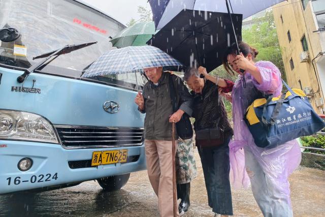 Officials help evacuate local residents in Lin'an district in Hangzhou, eastern China's Zhejiang province on August 9, 2026, as part of precautionary measures ahead of the arrival of Typhoon Dolphin. (Photo by CN-STR / AFP) / China OUT