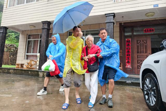Officials help evacuate local residents in Lin'an district in Hangzhou, eastern China's Zhejiang province on August 9, 2026, as part of precautionary measures ahead of the arrival of Typhoon Dolphin. (Photo by CN-STR / AFP) / China OUT