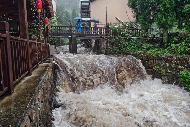 Officials help evacuate local residents in Lin'an district in Hangzhou, eastern China's Zhejiang province on August 9, 2026, as part of precautionary measures ahead of the arrival of Typhoon Dolphin. (Photo by CN-STR / AFP) / China OUT
