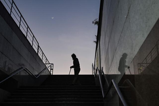 A man walks down the stairs of an underground subway, early morning in Chennai on August 10, 2026. (Photo by R. Satish BABU / AFP)