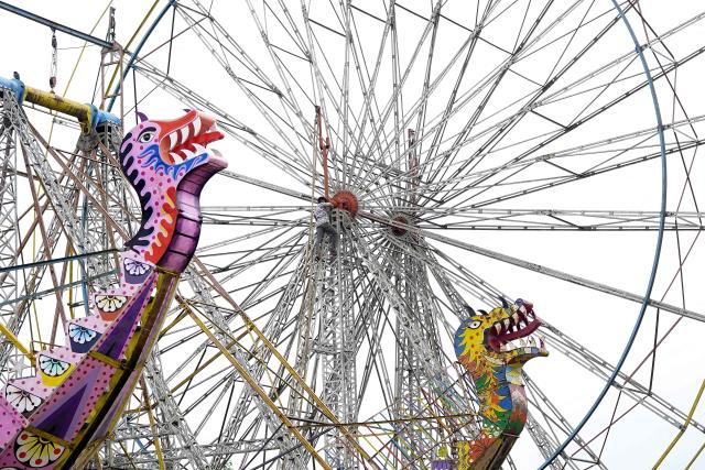 A worker installs a ferris wheel at a fairground on the outskirts of Ajmer on August 10, 2026. (Photo by HIMANSHU SHARMA / AFP)