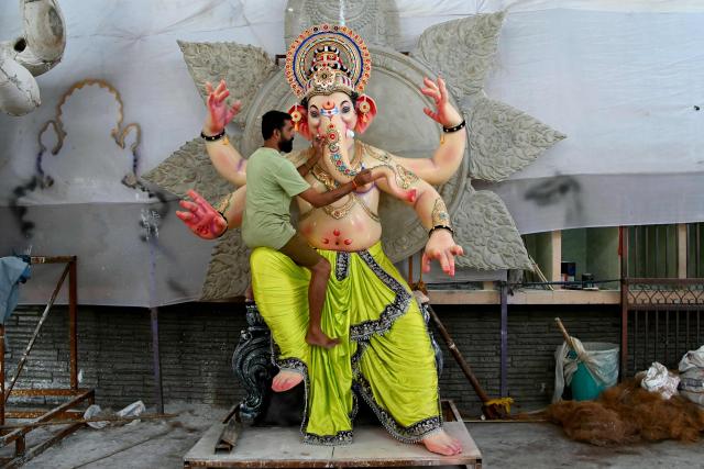 An artist decorates an idol of the elephant headed Hindu deity Ganesha at a workshop in Hyderabad on August 10, 2026 ahead of Ganesh Chaturthi festival. (Photo by Noah SEELAM / AFP)