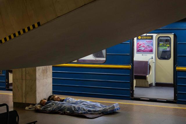 People sleep as they take shelter overnight, in a Kyiv metro station following warnings of a possible Russian air attack, on early August 10, 2026, amid the Russian invasion of Ukraine. By sunrise, no large-scale attack had taken place on the Ukranian capital as warnings continued for the coming days. (Photo by Serhii Okunev / AFP)