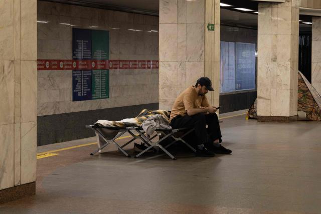 A man checks his smartphone as he takes shelter overnight in a Kyiv metro station, following warnings of a possible Russian air attack, on early August 10, 2026, amid the Russian invasion of Ukraine. By sunrise, no large-scale attack had taken place on the Ukranian capital as warnings continued for the coming days. (Photo by Serhii Okunev / AFP)